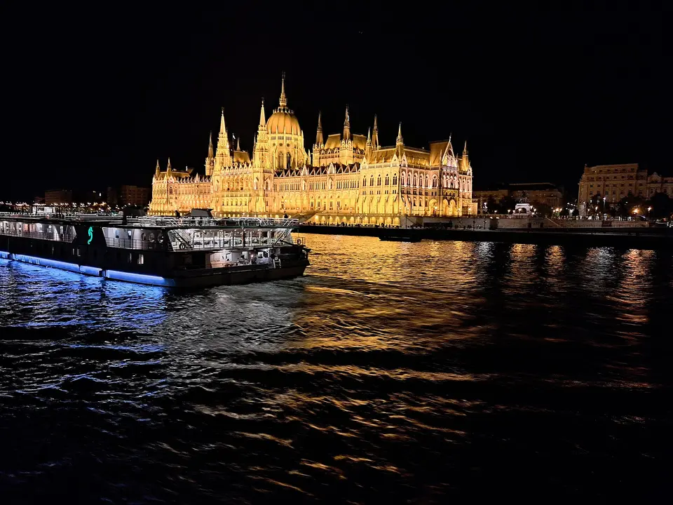 Candlelit dinner table on a Danube cruise boat with the illuminated Chain Bridge behind