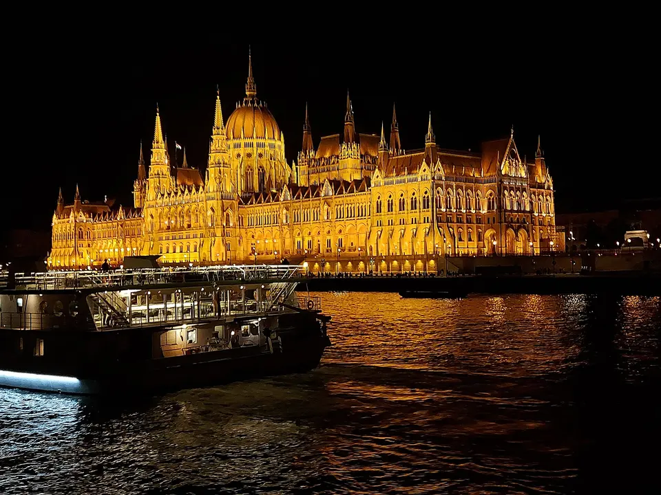 Illuminated Hungarian Parliament seen from a night cruise boat on the Danube