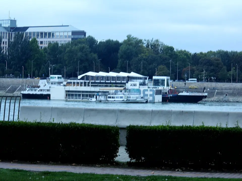 Crowd dancing on a party boat deck on the Danube with illuminated Budapest bridges behind